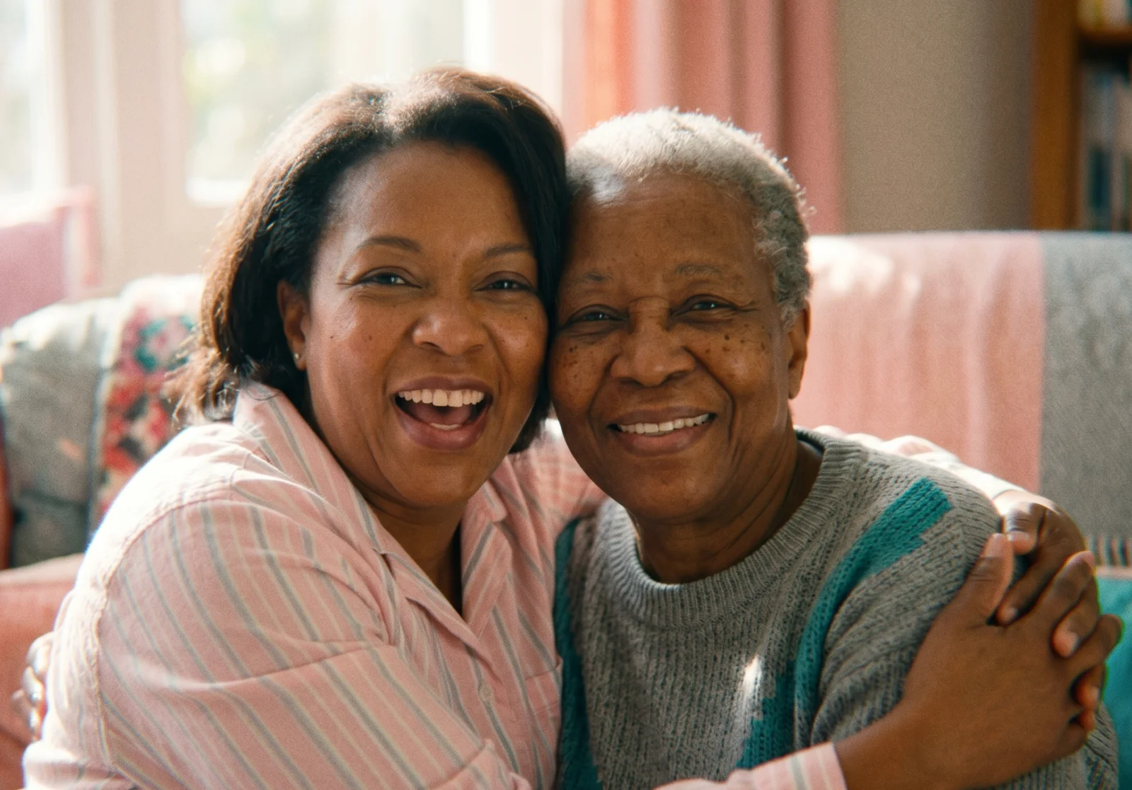 A caregiver and an older adult smiling together at home